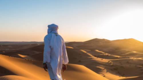 A local man walks atop sand dunes in the Sahara, Morocco | James Griesedieck