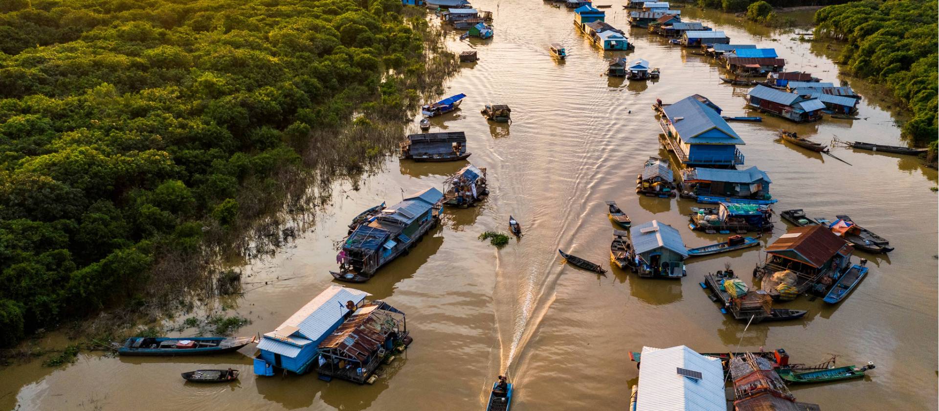 The sun setting over Mechrey floating village, Cambodia | Lachlan Gardiner