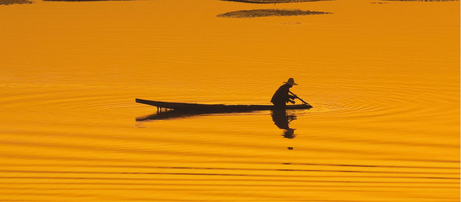 A silhouette of a boatman at sunset on the Mekong river in Vientiane, Laos