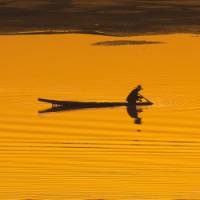 A silhouette of a boatman at sunset on the Mekong river in Vientiane, Laos