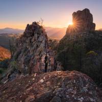 Sun rising over the Breadknife rock formation in Warrumbungle National Park. | Destination NSW