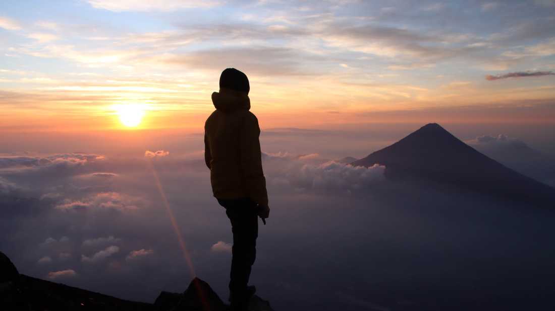 Hiker admiring the view from the summit of Volcan Acatenango