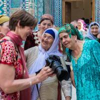 Pilgrims with traveller at Shah-i-Zinda, avenue of mausoleums, Samarkand | Richard I'Anson
