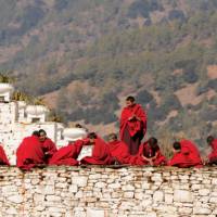 Bhutanese monks socialise along the monastery wall | Liz Light
