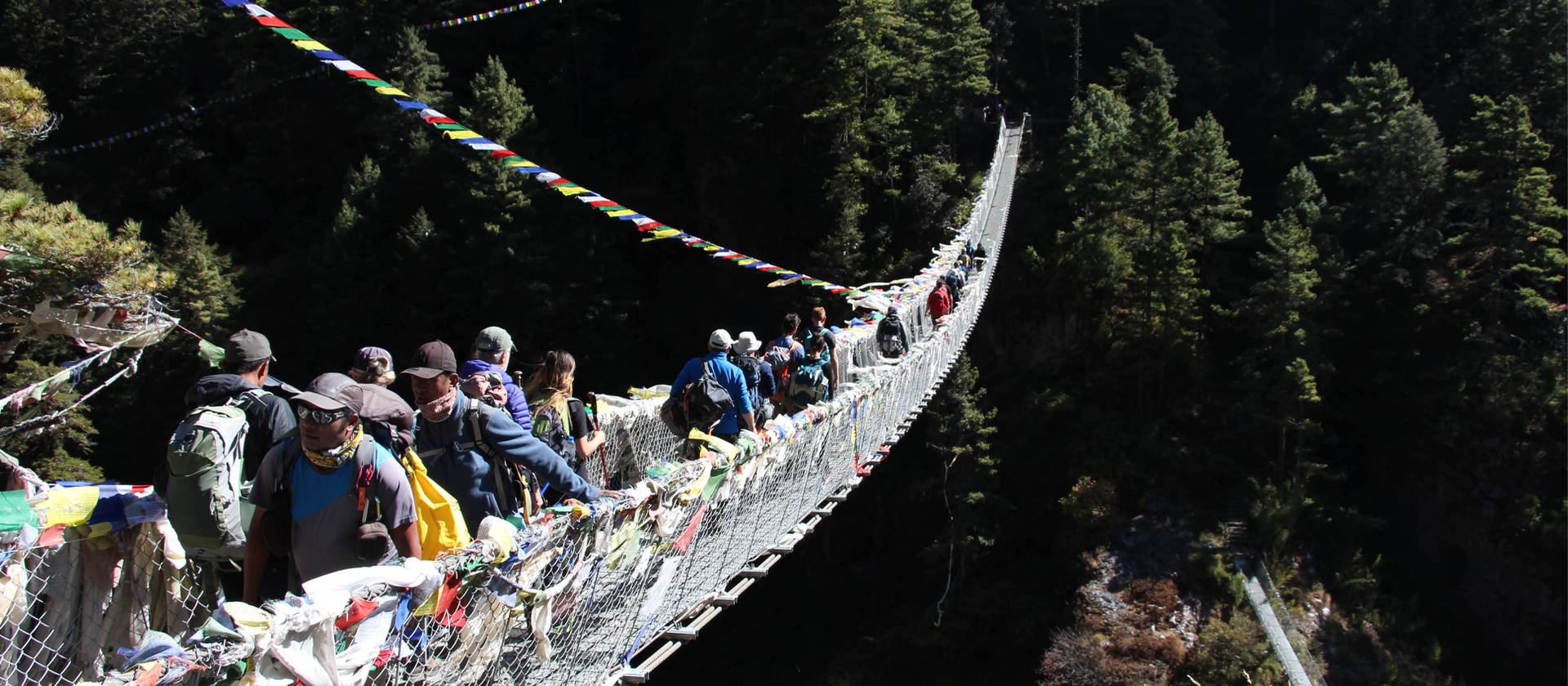 Prayer flags flying on a bridge crossing in the Everest Region | Ayla Rowe