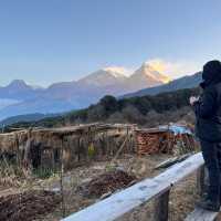 A World Expeditions trekker enjoys a warm cup of tea at daybreak to the breathtaking views of the Annapurna massif from our exclusive eco campsite at Pulbari | Sue Badyari