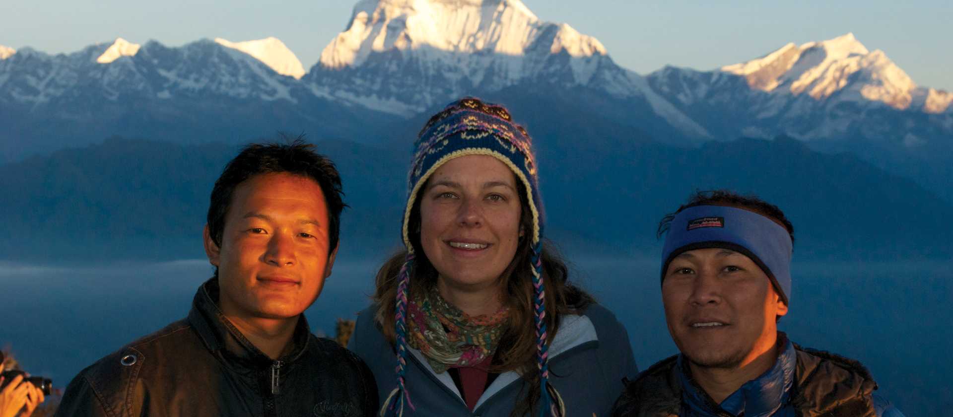 Local Nepali staff and happy trekker enjoy sunrise at Poon Hill, Annapurna region | Carlie Ballard