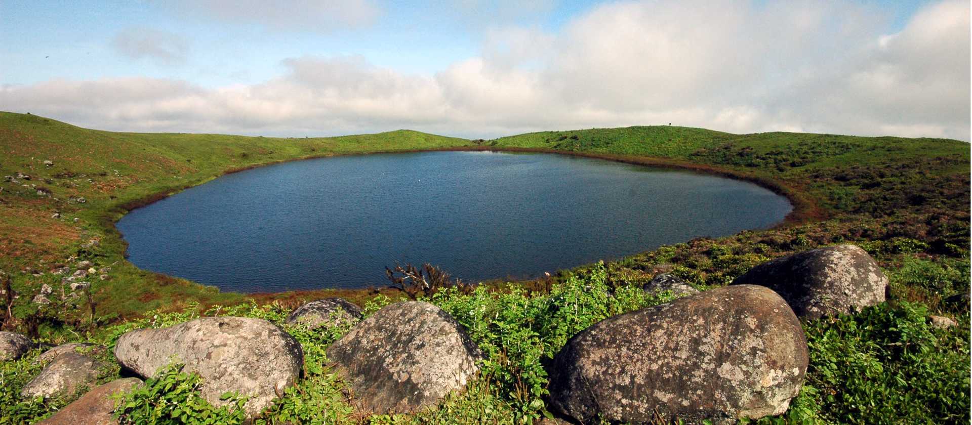 The deep turquoise waters of Lake Cristobal glimmer under the clear blue skies.