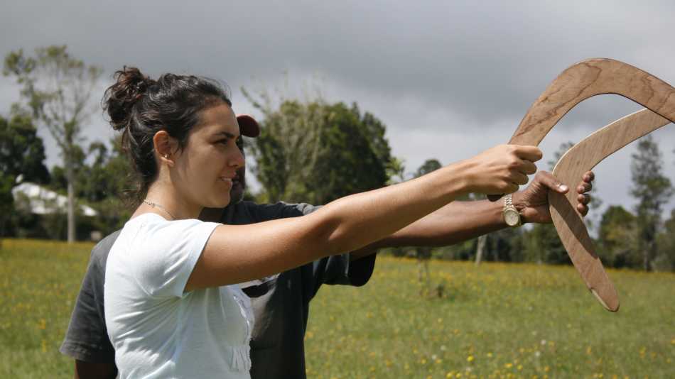 students learning how to throw boomerangs on Country