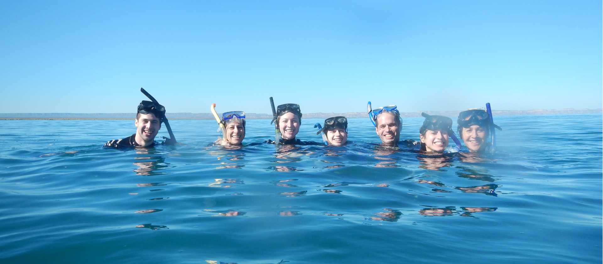 Happy students swimming with the whale sharks in Bajas