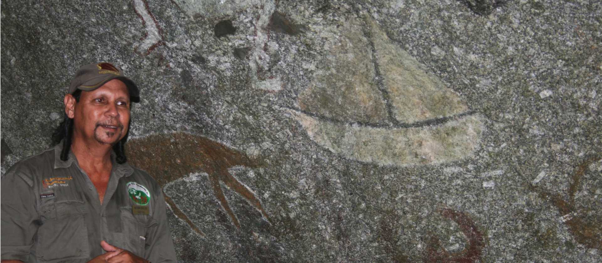 Indigenous guide explaining the rock art on a dreamtime walk | SWJ