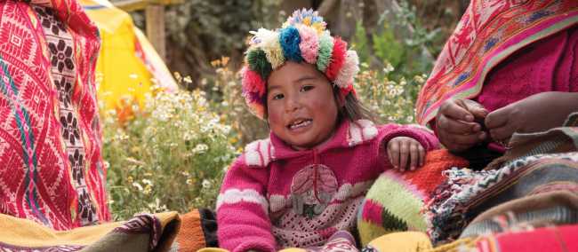 The young children of Huilloc spend the day by their mothers side as she sells her handcrafted weaving products | Mark Tipple