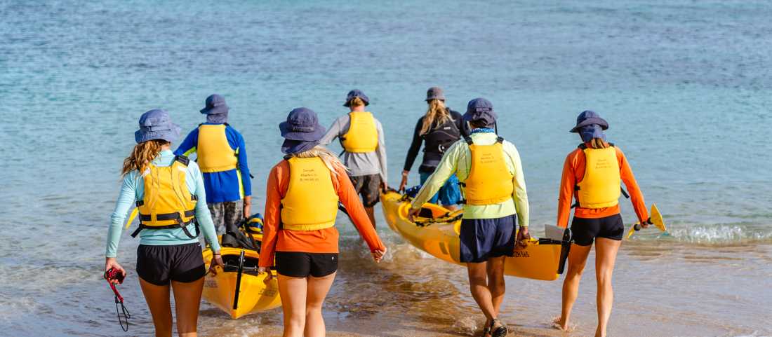 Students launching their kayaks, ready to continue their kayaking expedition.